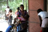 A Haitian mother holds her child at a school in Fond Parisien on July 3, 2015, after she was arrested and deported from the Dominican Republic