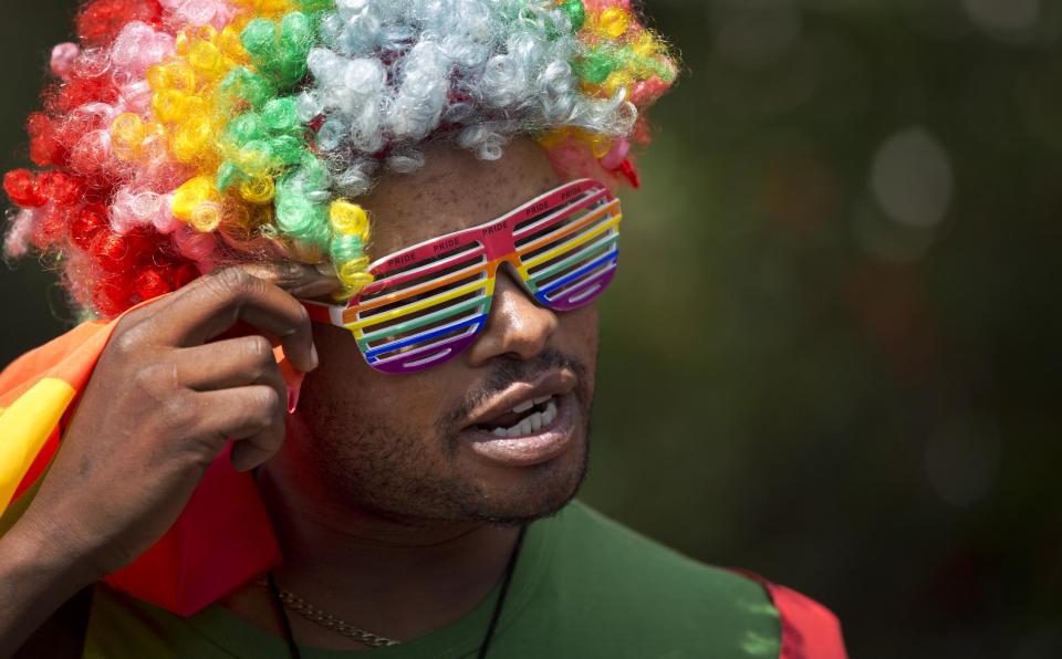 A protester wears a rainbow-colored wig and glasses as Kenyan gays and lesbians and others supporting their cause stage a rare protest, against Uganda's increasingly tough stance against homosexuality and in solidarity with their counterparts there, outside the Uganda High Commission in Nairobi, Kenya Monday, Feb. 10, 2014. Homosexuality has been criminalized in Uganda where lawmakers have recently passed a new bill, which appears to have wide support among Ugandans, that prescribes life imprisonment for "aggravated" homosexual acts. (AP Photo/Ben Curtis)