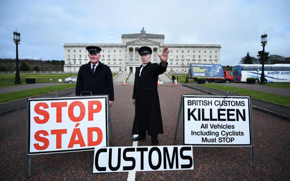 Two men dressed as customs officers take part in a protest outside Stormont against Brexit and its possible effect on the north and south Irish border on March 29, 2017 in Belfast - Getty Images