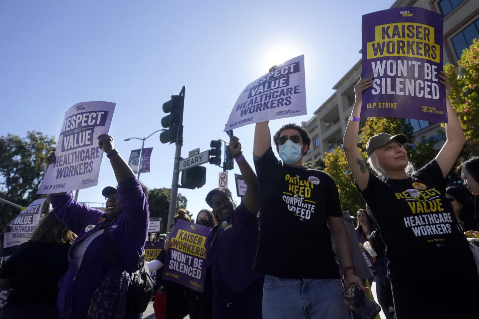 Medical workers and supporters hold signs as they protest outside of a Kaiser Permanente facility in San Francisco, Wednesday, Oct. 4, 2023. Some 75,000 Kaiser Permanente hospital employees who say understaffing is hurting patient care walked off the job Wednesday in five states and the District of Columbia, kicking off a major health care worker strike. (AP Photo/Jeff Chiu)