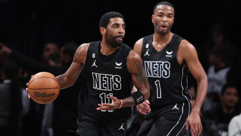 Brooklyn Nets guard Kyrie Irving (11) dribbles in front of forward T.J. Warren (1) during the first half against the Toronto Raptors