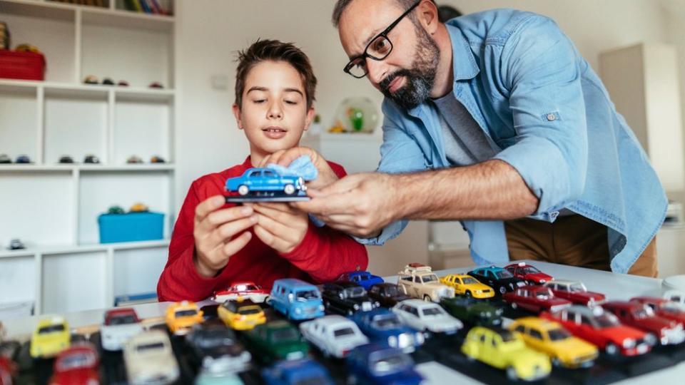 Padre e hijo con una colección de autos