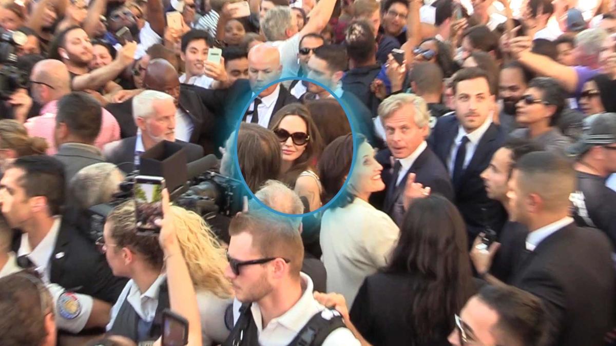 Angelina Jolie is mobbed by fans while signing autographs in Paris