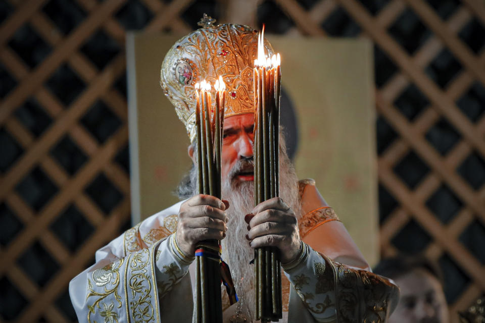 Orthodox Archbishop Teodosie prepares to distribute holy light during a religious service in the Black Sea port of Constanta, Romania, shortly before midnight on Tuesday, May 26, 2020. (AP Photo/Vadim Ghirda)