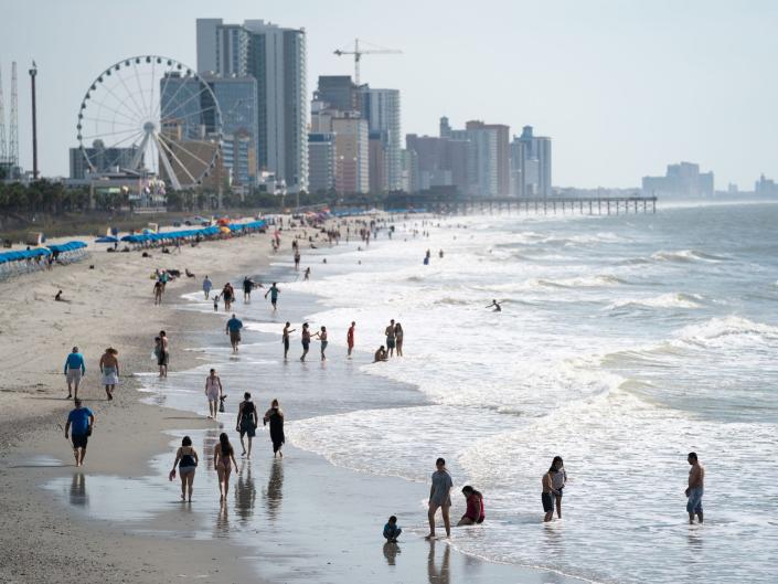 People walk along the beach the morning of May 29, 2021 in Myrtle Beach, South Carolina.