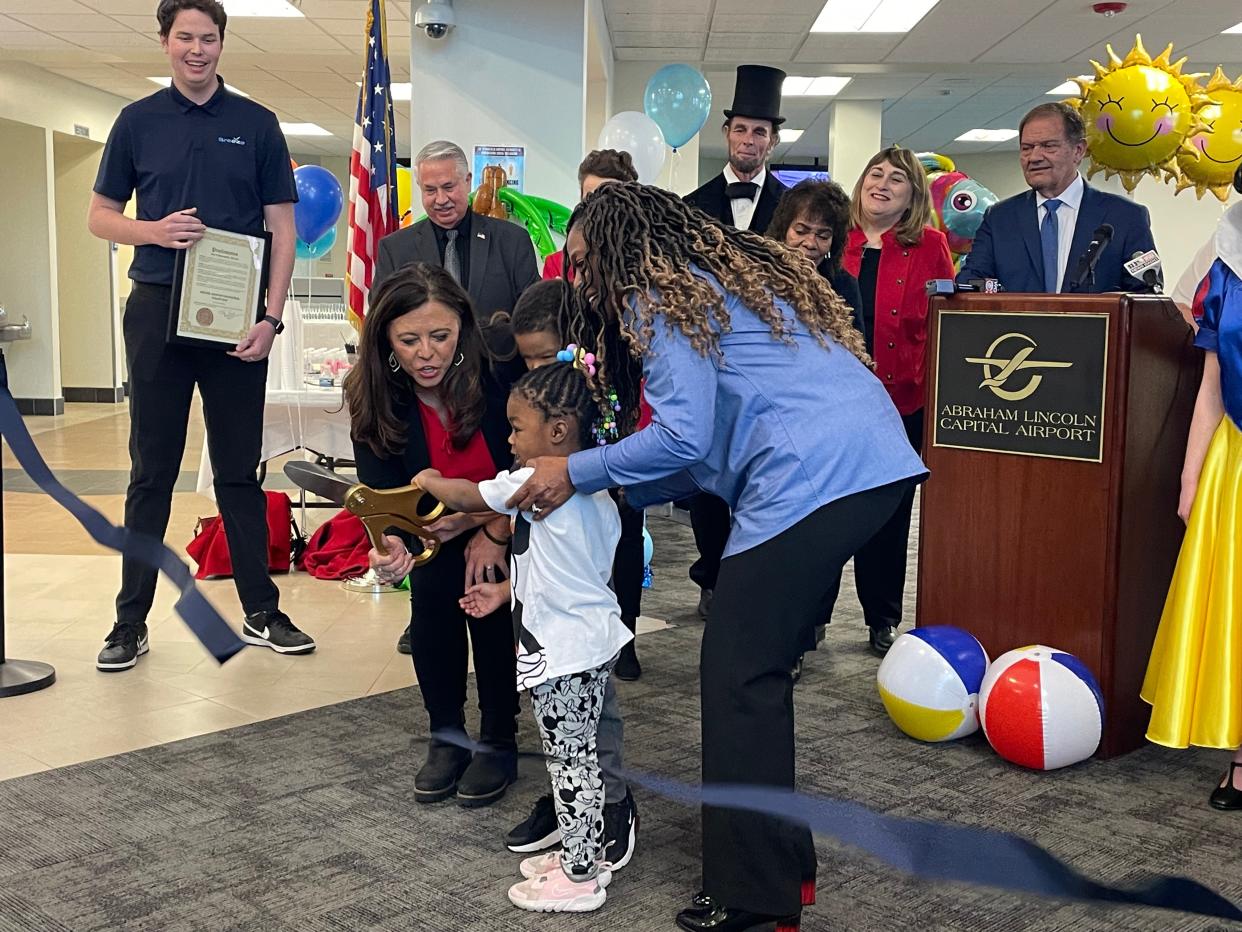 Springfield Mayor Misty Buscher and Airport Authority Commissioner Teresa Haley help Cameron and Kozey Major, 6 and 3-years-old, respectively, cut the ribbon to welcome Breeze Airways to Abraham Lincoln Capital Airport Friday, Dec. 1, 2023. Cameron and Kozey were among the first passengers on the inaugural flight to Orlando.