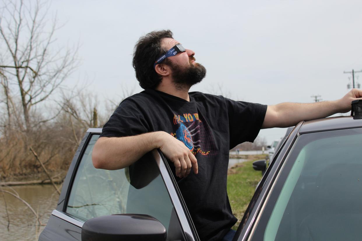 Jackson Kelly of Lansing stood by his car to watch the solar eclipse at the Erie State Game Area.