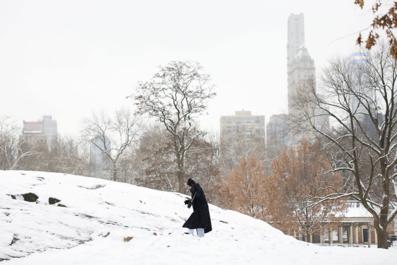 Pedestrians brave the cold and snow in New York City on Tuesday. Winter weather canceled at least a dozen Amtrak routes into the city Thursday. Photo by John Angelillo/UPI