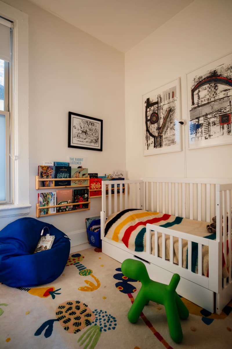 Colorful striped bedding made on bed in kid's room.