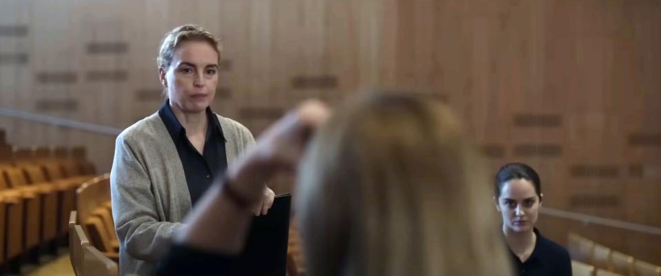 Nina Hoss stands in a concert hall with Noemie Merlant and Cate Blanchett