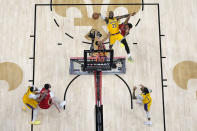 Los Angeles Lakers forward LeBron James (23) shoots between New Orleans Pelicans guard Trey Murphy III and guard CJ McCollum in the second half of an NBA basketball play-in tournament game Tuesday, April 16, 2024, in New Orleans. The Lakers won 110-106. (AP Photo/Gerald Herbert)