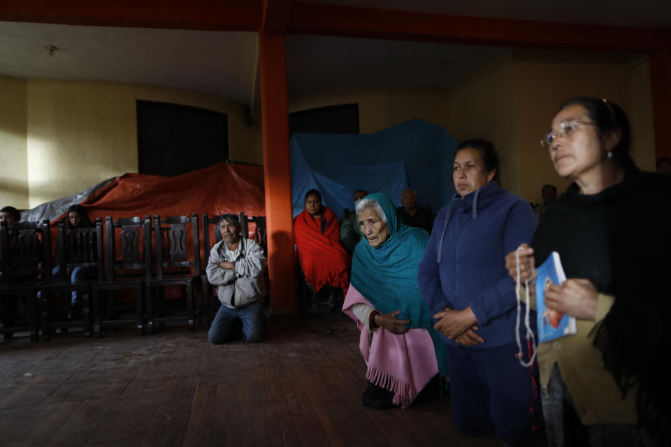 Mourners kneel in prayer around the coffin of environmental activist Homero Gomez Gonzalez at his wake in Ocampo, Michoacan state, Mexico, Thursday, Jan. 30, 2020. Relatives of the anti-logging activist who fought to protect the winter habitat of monarch butterflies don't know whether he was murdered or died accidentally, but they say they do know one thing for sure: something bad is happening to rights and environmental activists in Mexico, and people are afraid. (AP Photo/Rebecca Blackwell)