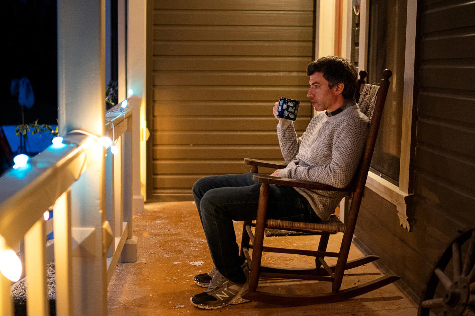 A man drinking coffee on a rocking chair