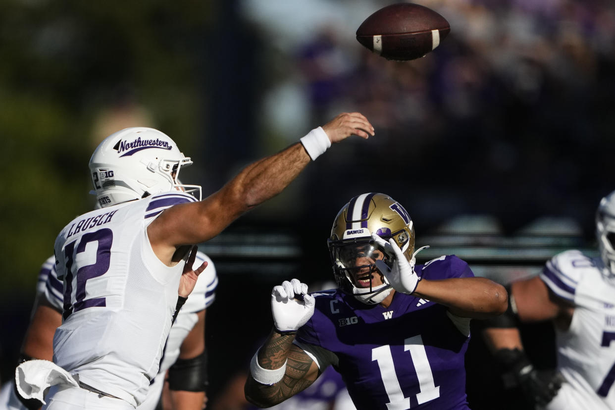 Northwestern quarterback Jack Lausch (12) is pressured by Washington linebacker Alphonzo Tuputala (11) during the first half of an NCAA college football game Saturday, Sept. 21, 2024, in Seattle. (AP Photo/Lindsey Wasson)