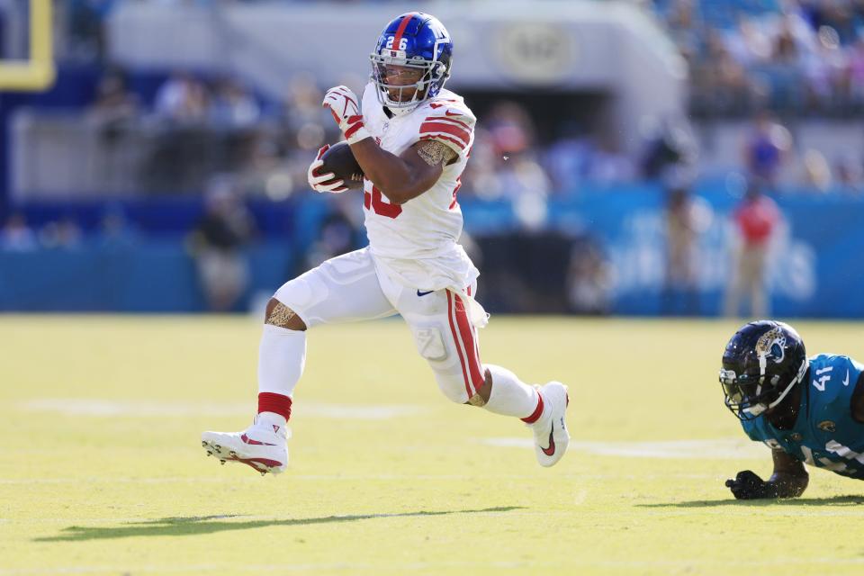 New York Giants running back Saquon Barkley (26) rushes for yards against Jacksonville Jaguars linebacker Josh Allen (41) during the fourth quarter of a regular season NFL football matchup Sunday, Oct. 23, 2022 at TIAA Bank Field in Jacksonville. The New York Giants defeated the Jacksonville Jaguars 23-17. [Corey Perrine/Florida Times-Union]