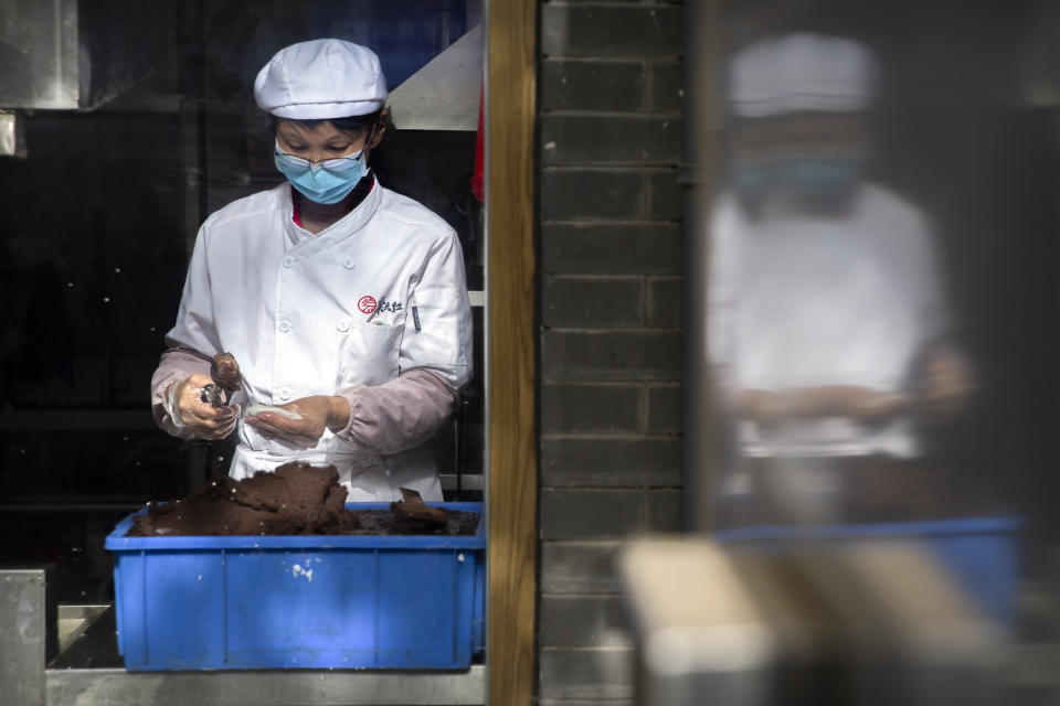 A chef wearing a face mask prepares food at a shop on a pedestrian shopping street in Beijing, Saturday, May 16, 2020. According to official data released on Saturday India's confirmed coronavirus cases have surpassed China's. (AP Photo/Mark Schiefelbein)