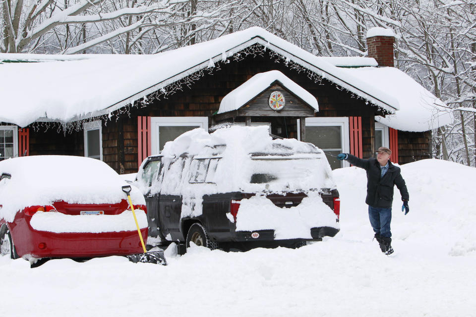 Donald Croteau works to clear nearly a foot of snow off his car on the first day of spring, Thursday, March 20, 2014 in North Woodstock, N.H. Much of the country remains in a deep freeze, delaying the risk of spring flooding into April in the upper Midwest to New England. While major flooding is not expected, experts say there's a moderate risk of flooding in the southern Great Lakes region because of above-average snowpack. (AP Photo/Jim Cole)