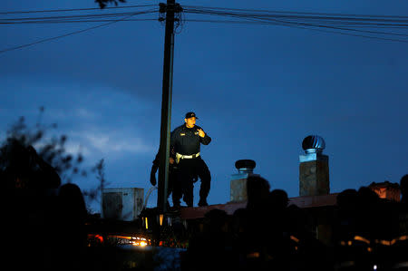 A local police officer patrols on a roof as they arrive to confiscate a villa built illegally by an alleged Mafia family in Rome, Italy, November 20, 2018. REUTERS/Yara Nardi