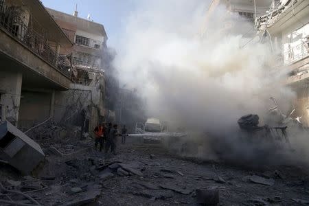 Civil defense members try to put out a fire at a site hit by what activists said were airstrikes by forces loyal to Syria's President Bashar al-Assad in the Douma neighborhood of Damascus, Syria August 24, 2015. REUTERS/Bassam Khabieh