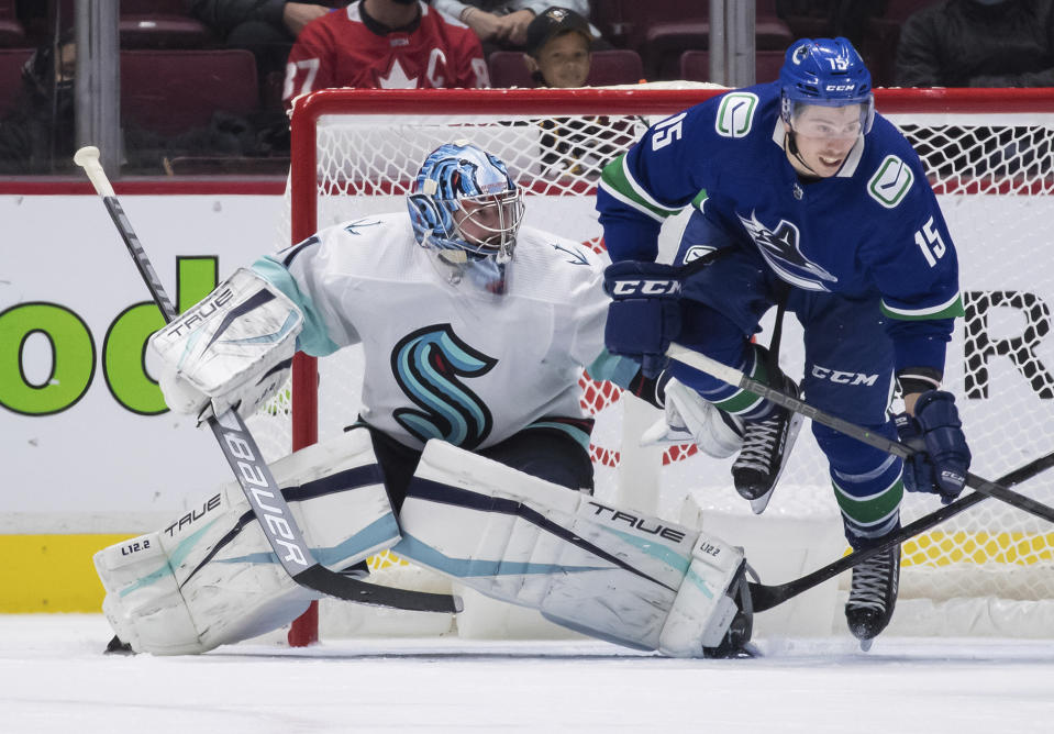 Vancouver Canucks' Matthew Highmore (15) is tripped in front of Seattle Kraken goalie Philipp Grubauer, of Germany, during the third period of an NHL preseason hockey game, Tuesday, Oct. 5, 2021 in Vancouver, British Columbia (Darryl Dyck/The Canadian Press via AP)