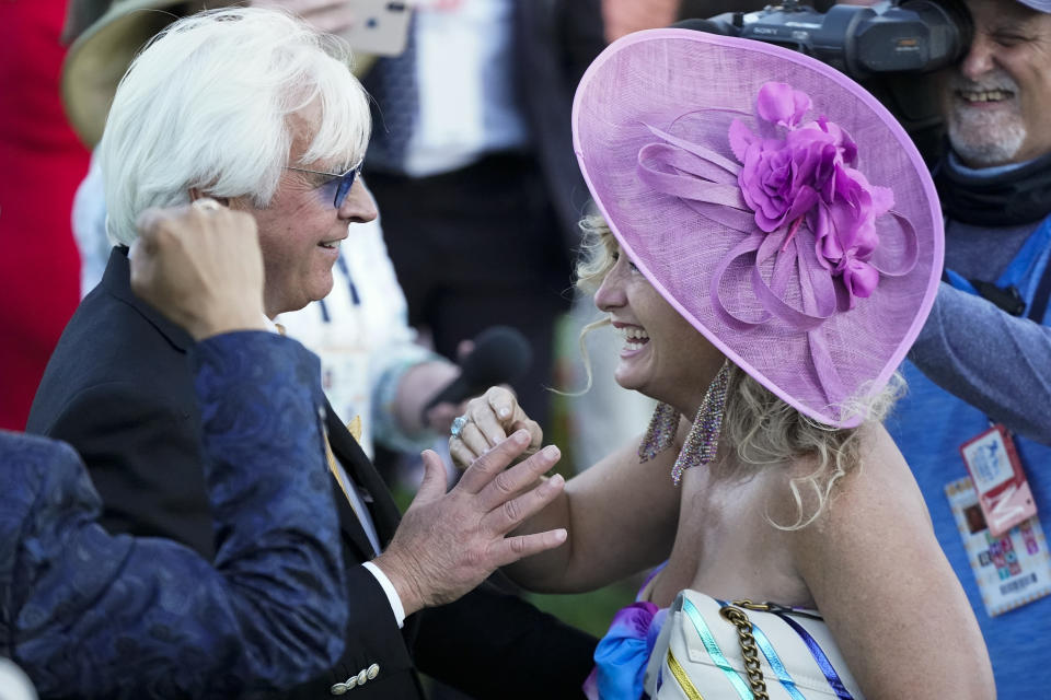 CORRECTS PERSON AT RIGHT TO LEONA O'BRIEN - Trainer Bob Baffert is greeted by Leona O'Brien, wife of jockey John Velazquez, after Medina Spirit won the 147th running of the Kentucky Derby horse race at Churchill Downs, Saturday, May 1, 2021, in Louisville, Ky. (AP Photo/Jeff Roberson)