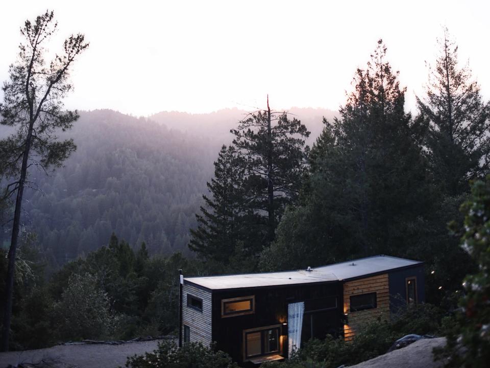 Bela Fishbeyn tiny house with trees and mountains in the background