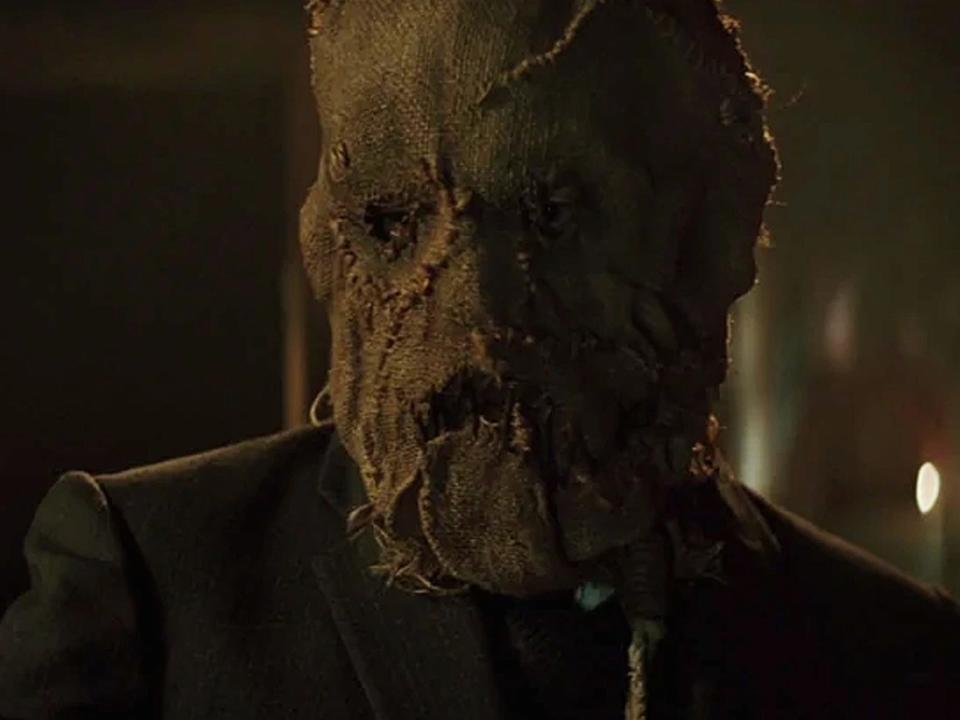 Cillian Murphy in a scene from "Batman Begins" where Scarecrow is wearing a burlap mask over his face.
