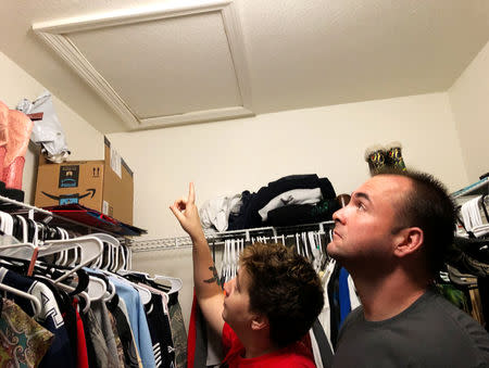 Air Force Technical Sgt. Ann Yarbrough, with husband Michael, pointS to the entrance of their attic, where workers found a mold infestation in their home at Keesler Air Force base in Biloxi, Mississippi, U.S. December 7, 2018. REUTERS/Deborah Nelson