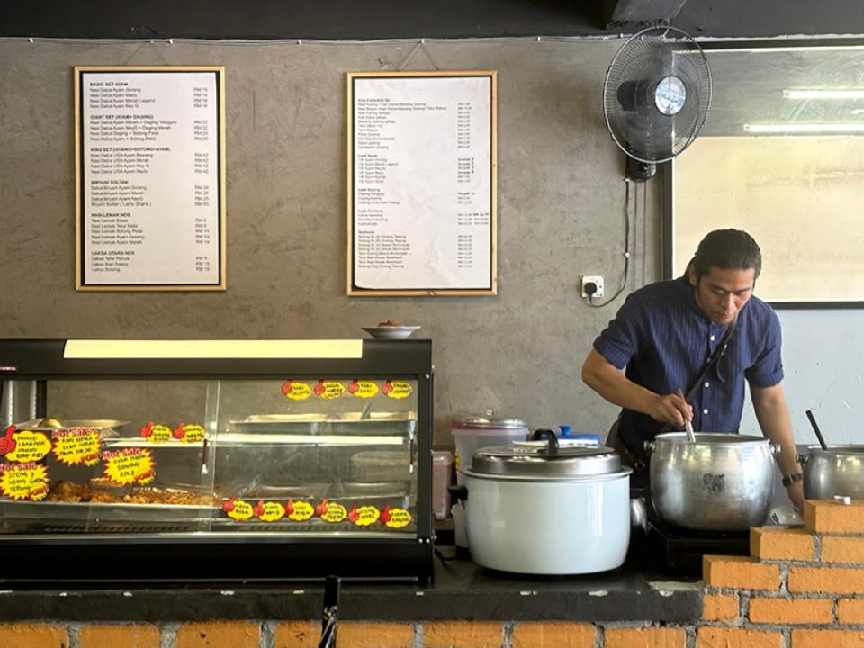 Find an array of dishes laid out in pots and the counter at Nasi Dalca Salsabila.