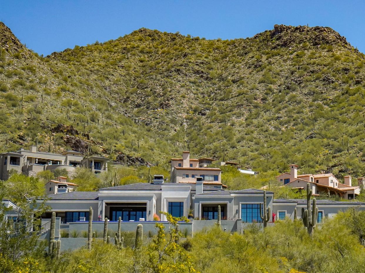 Mansions on a mountain dotted with bushes and cacti