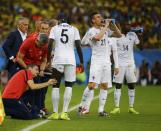 France's Mamadou Sakho receives medical attention as his teammates drink water during their 2014 World Cup Group E soccer match against Ecuador at the Maracana stadium in Rio de Janeiro June 25, 2014. REUTERS/Kai Pfaffenbach