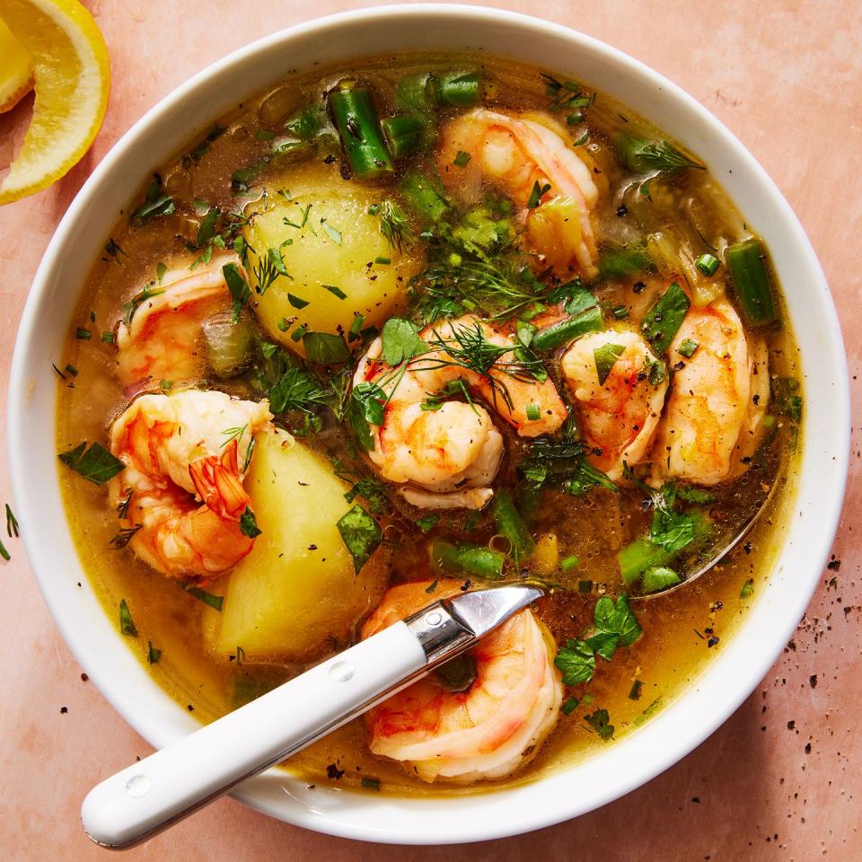 shrimp potato soup in a pot topped with herbs