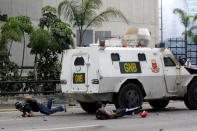 Demonstrators fall on the ground after being hit by a riot police armoured vehicle while clashing with the riot police during a rally against Venezuelan President Nicolas Maduro in Caracas, Venezuela May 3, 2017. REUTERS/Marco Bello