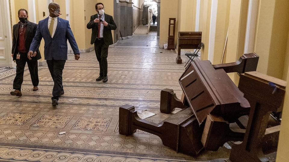 Sen. Tim Scott, R-S.C., second from left, walks past damage in the early morning hours of Thursday, Jan. 7, 2021, after protesters stormed the Capitol in Washington, on Wednesday.