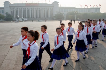 Pupils arrive at a wreath laying ceremony at the Monument to the People's Heroes in Tiananmen Square in Beijing