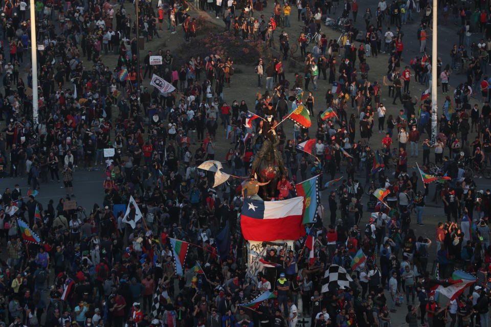 People gather for an anti-government protest in Santiago, Chile Friday, Nov. 1, 2019. Groups of Chileans continued to demonstrate as government and opposition leaders debate the response to nearly two weeks of protests that have paralyzed much of the capital and forced the cancellation of two major international summits. (AP Photo/Esteban Felix)