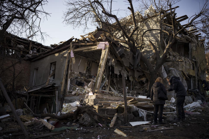 Serhii Kaharlytskyi, right, stands outside his home, destroyed after a Russian attack in Kyiv, Ukraine, Monday, Jan. 2, 2023. Kaharlytskyi's wife Iryna died in the attack on Dec. 31, 2022. (AP Photo/Renata Brito)