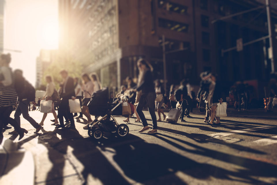 People walking at the crossroad at sunset carrying shopping bags. Sydney, Australia