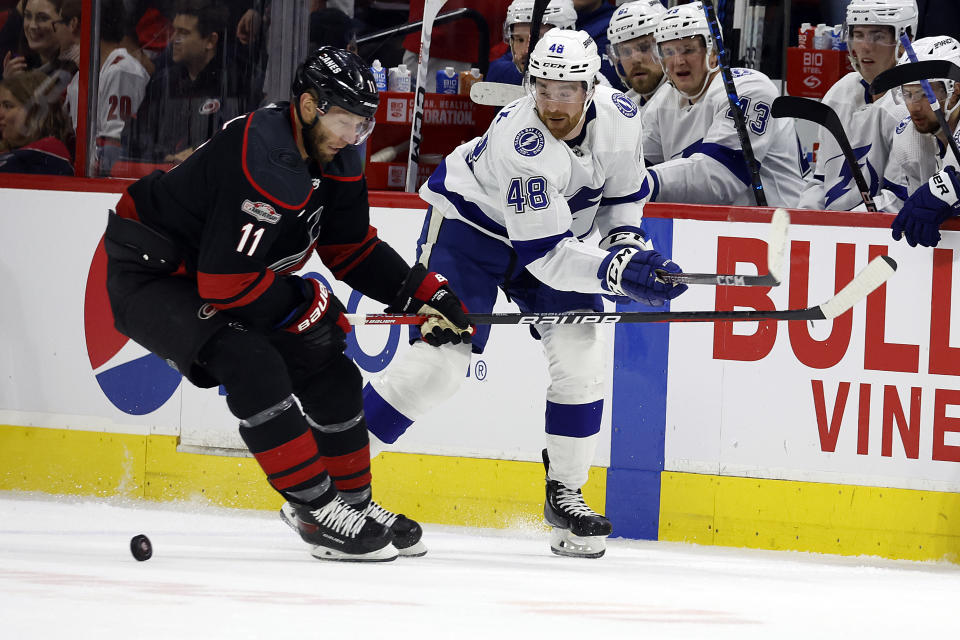 Tampa Bay Lightning's Nick Perbix (48) passes the puck pat Carolina Hurricanes' Jordan Staal (11) during the first period of an NHL hockey game in Raleigh, N.C., Tuesday, March 28, 2023. (AP Photo/Karl B DeBlaker)