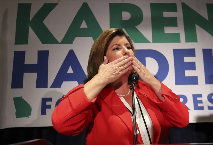 Karen Handel blows a kiss with her husband Steve looking on while making an early appearance to thank her supporters after the first returns came in during her election night party in the 6th District race with Jon Ossoff on Tuesday, June 20, 2017, in Atlanta. (Curtis Compton/Atlanta Journal-Constitution via AP)