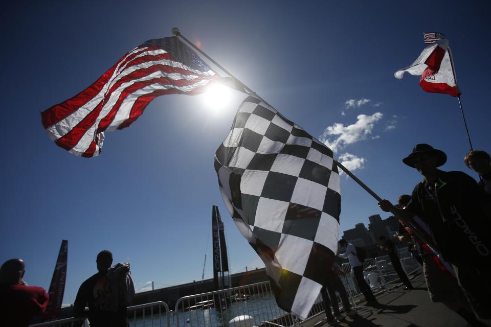 Sailing fan carries American flag before Race 19 of the 34th America's Cup yacht sailing race between Oracle Team USA and Emirates Team New Zealand in San Francisco