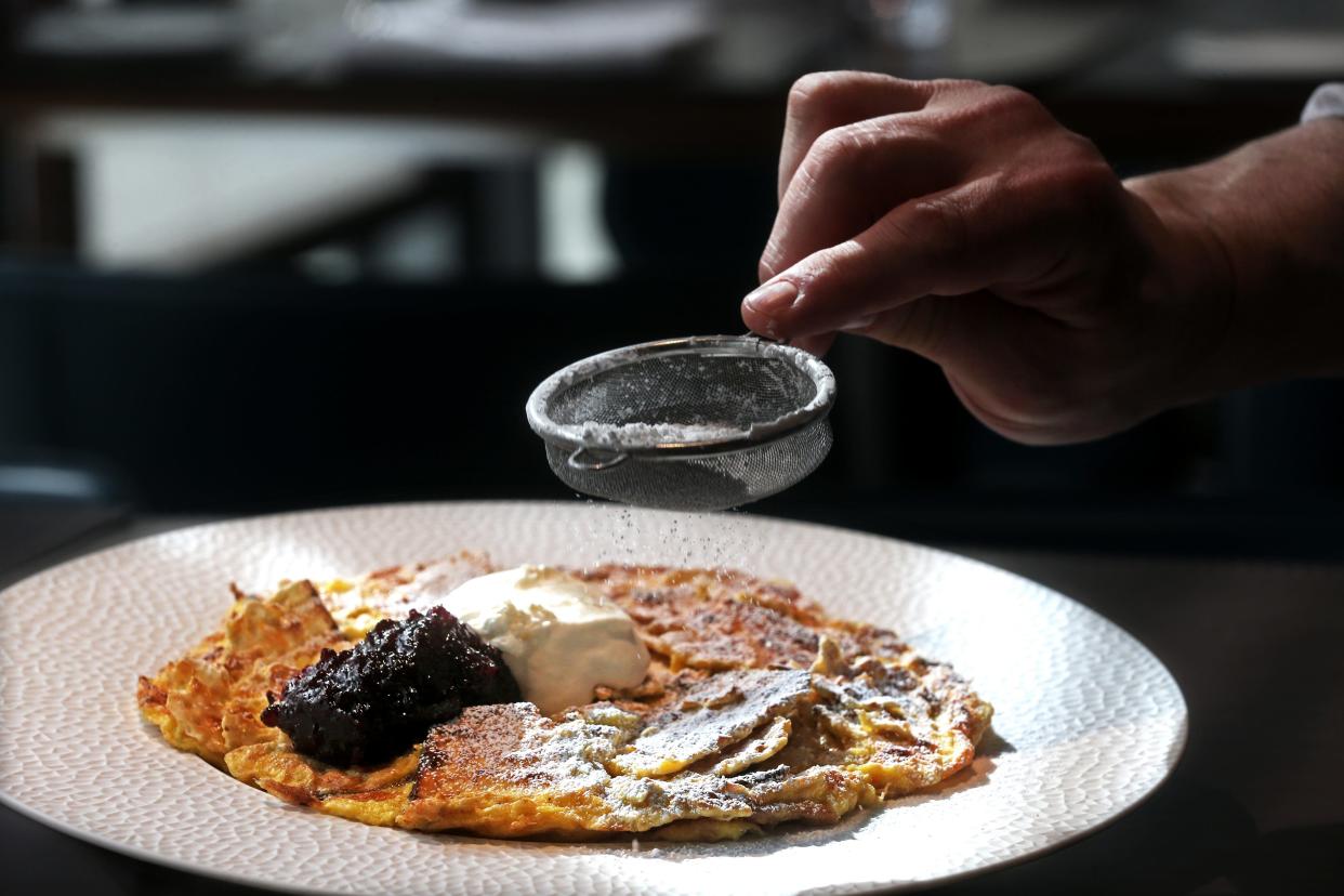 Chef Adam Siegel from Lupi and Iris restaurant sprinkles powdered sugar on a sweet matzah brei, a traditional dish prepared during Passover, on  March 24.