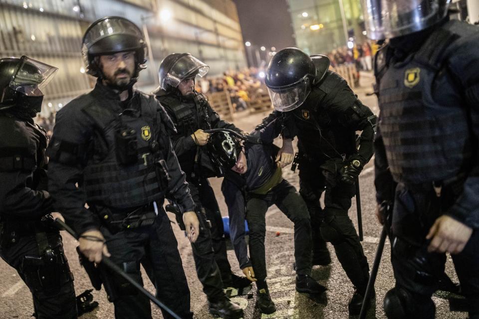 Police detain a protester during a demonstration at El Prat airport, outskirts of Barcelona, Spain, Monday, Oct. 14, 2019. Spain's Supreme Court on Monday sentenced 12 prominent former Catalan politicians and activists to lengthly prison terms for their roles in a 2017 bid to gain Catalonia's independence, sparking protests across the wealthy Spanish region. (AP Photo/Bernat Armangue)