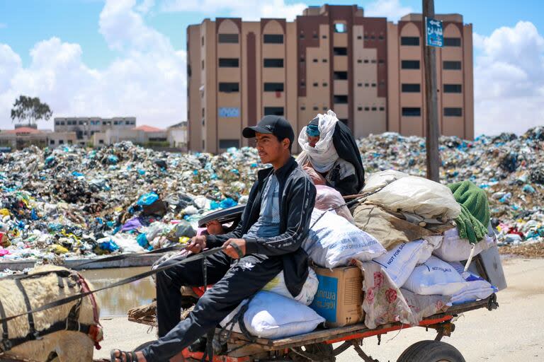 Los palestinos desplazados que partieron con sus pertenencias desde Rafah, en el sur de la Franja de Gaza, tras una orden de evacuación del ejército israelí, llegan a Khan Yunis el 6 de mayo de 2024, en medio del conflicto en curso entre Israel y el movimiento palestino Hamas.