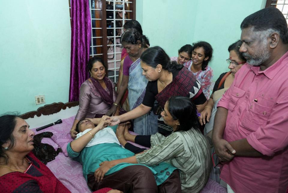 Kerala’s health minister Veena George consoles the mother of Akash Sasidharan Nair, one of the victims of the Kuwait fire (Reuters)