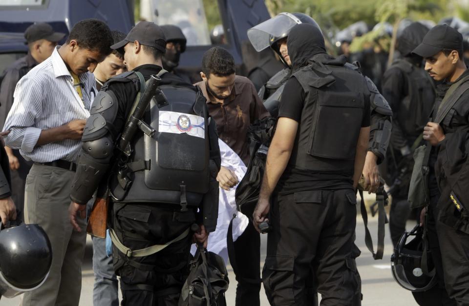 Riot police search students before letting them exit the al-Azhar university campus after clashes broke out during student protests in Cairo October 30, 2013. Egyptian police fired teargas at protesting students at Cairo's al-Azhar university on Wednesday hours after authorities announced the detention of Muslim Brotherhood leader Essam El-Erian, part of a crackdown against the Islamist movement. (REUTERS/Mohamed Abd El Ghany)