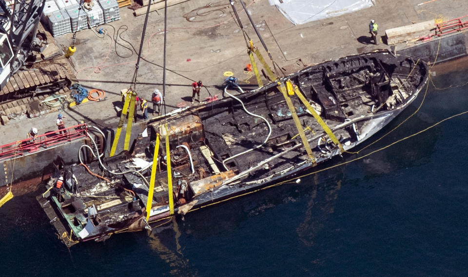 FILE - In this Sept. 12, 2019, file photo, the burned hull of the dive boat Conception is brought to the surface by a salvage team off Santa Cruz Island, Calif. Deaths from California fires on the scuba diving boat and at the so-called Ghost Ship warehouse have brought a search for blame aimed at finding whether someone was negligent. Getting criminal charges to stick in the 2016 fire at the Ghost Ship warehouse has proven difficult and could provide lessons as investigators decide whether a crime occurred aboard the Conception scuba diving boat that burned this month. (Brian van der Brug/Los Angeles Times via AP, File)