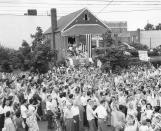 FILE - In this June 18, 1949, file photo, a crowd gathers in front of Jake Lamotta's home in the Bronx borough of New York, welcoming him home from Detroit where he won the middleweight boxing world championship against Marcel Cerdan. The movie "Raging Bull," about the life of Jake Lamotta, was No. 7 in The Associated Press’ Top 25 favorite sports movies poll. (AP Photo/File)