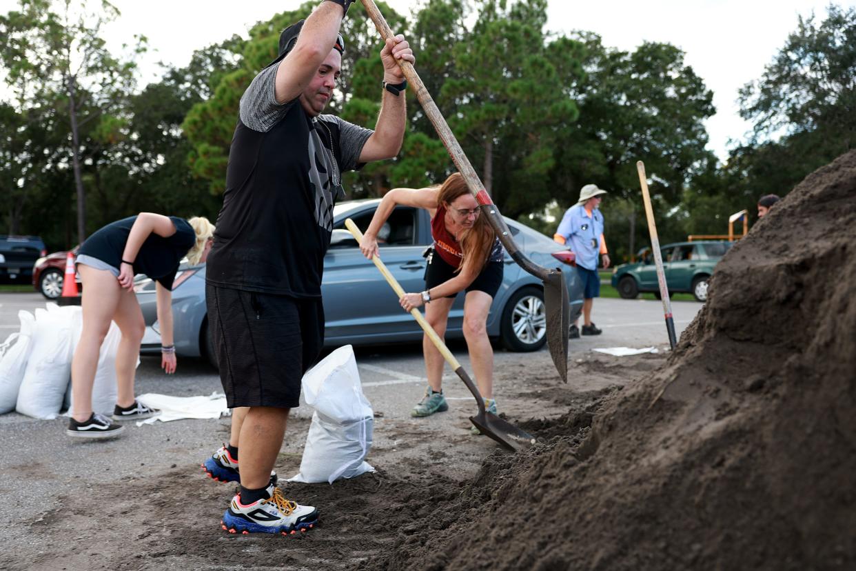 Alex Rico and other people fill sandbags at Helen Howarth Park as they prepare for the possible arrival of Hurricane Ian on Sept. 26, 2022, in St Petersburg, Fla. Ian is projected to make its closest pass to the Tampa Bay area on Wednesday with the current track putting the center 25 miles west of the coastline as it parallels the coast.