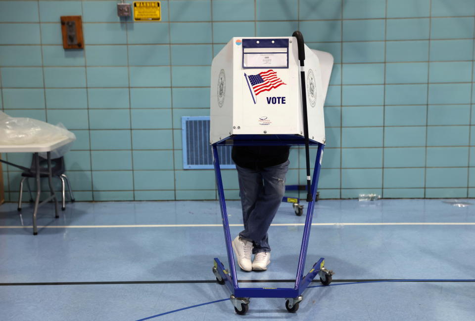 A walking stick hangs on a privacy booth as a person votes during the New York City Mayoral election at PS 81 in Brooklyn, New York City, U.S. November 2, 2021. REUTERS/Andrew Kelly